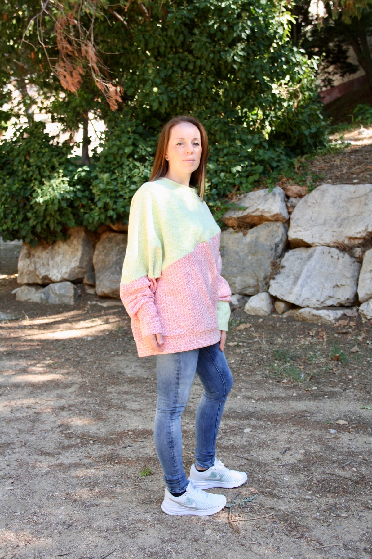 Jersey de lactancia bicolor en punto texturizado verde menta y rosa, con corte holgado y diseño asimétrico.