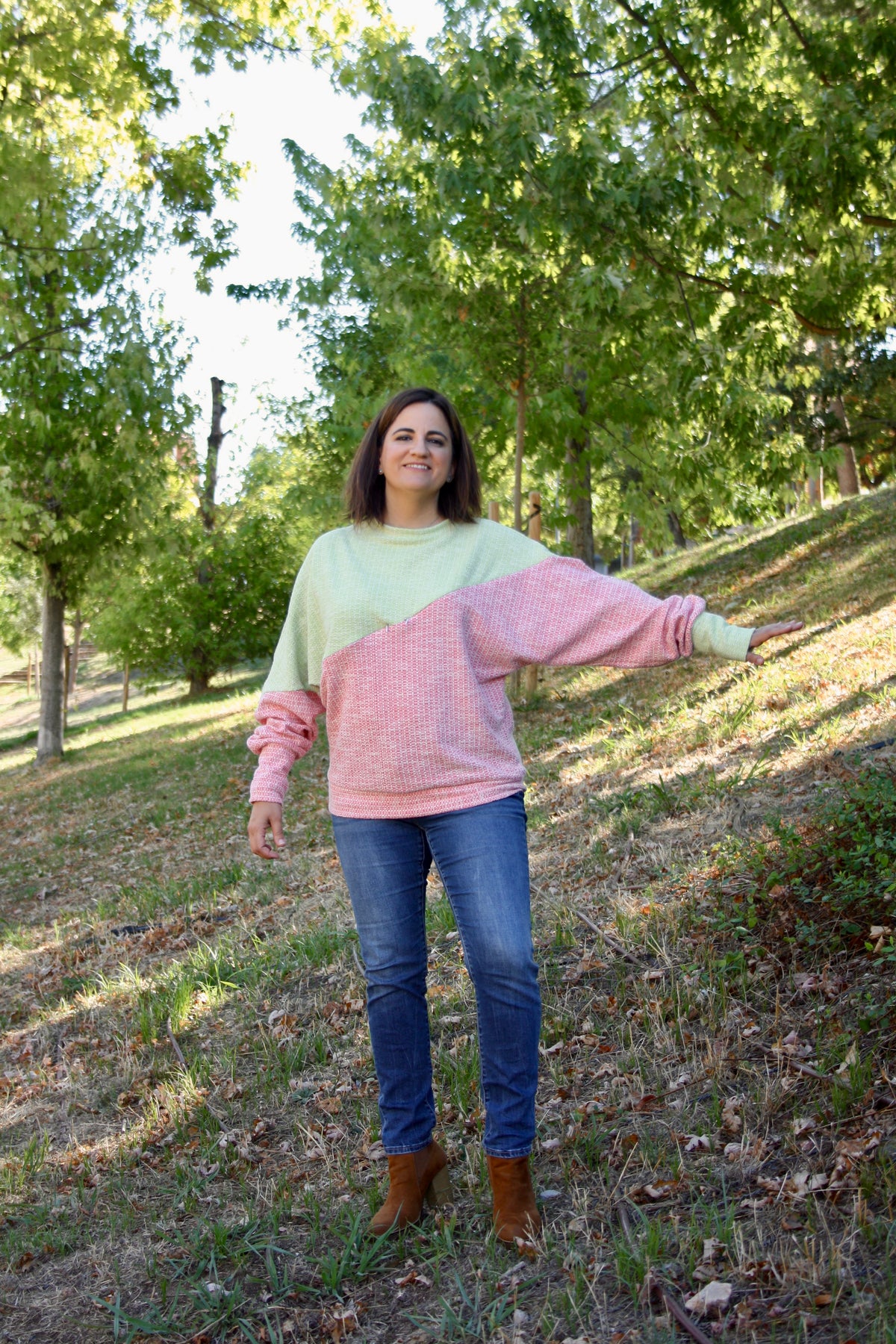 Jersey de lactancia bicolor en punto texturizado verde menta y rosa, con corte holgado y diseño asimétrico.